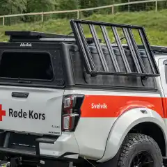 Enkel skyvemekanisme gjør at du kan vippe takgrinden ut og ned på den ene siden av bilen. Økt sikkerhet og enkel lasting og lossing.<br><br>Dimensjon: 1300 mm x 1350 mm x 90<br><br>Bildet viser Smart Rack montert på en Alu-Cab plantopp, det forutsetter en del modifisering. Smart Rack anbefales montert på SmartCap plantopp.<br><br><strong>NB! Noen bilder avviker. Denne modellen kan senkes ned på høyre side av bilen!</strong>